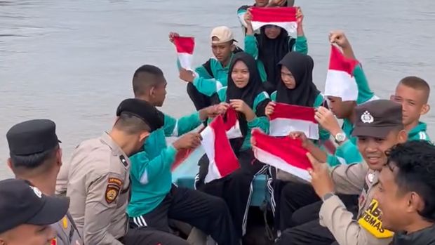 Polisi dan Paskibran mengibarkan bendera Merah Putih di Perairan Concong, Inhil, Kamis (14/8/2025).