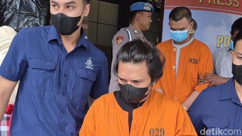 Pria berinisial IWP yang ditetapkan sebagai tersangka kasus prostitusi online digiring polisi saat konferensi pers di Mapolres Bangli, Jumat (15/8/2025). (Foto: Ni Komang Ayu Leona W/detikBali)