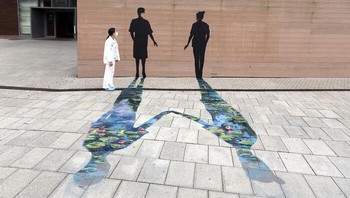 Seseorang memperhatikan mural yang tampak seperti dua orang sungguhan. Foto: via BoredPanda