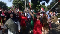 Dengan mengenakan busana beragam warna dan atribut bernuansa merah putih, para ASN berjalan beriringan sambil melambaikan tangan kepada warga yang memadati tepi jalan. Musik dan sorak-sorai penonton menambah suasana riang gembira. ANTARA FOTO/Yulius Satria Wijaya