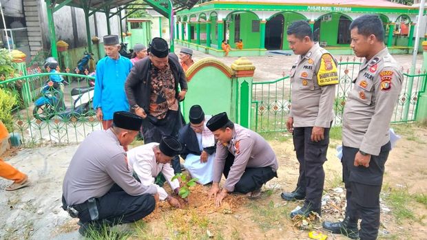 LAM Medang Kampai dan Polisi menanam pohon di halaman masjid.