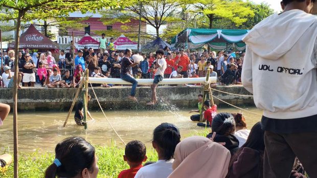 Lomba panjat pinang di Kalimalang, Jakarta Timur, meriahkan Hari Kemerdekaan RI ke-80. (Kurniawan/detikcm)