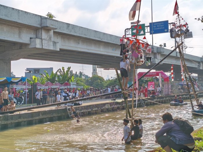 Lomba panjat pinang di Kalimalang, Jakarta Timur, meriahkan Hari Kemerdekaan RI ke-80. (Kurniawan/detikcm)