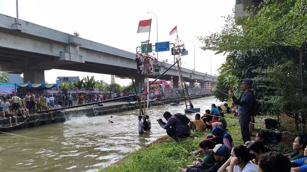 Lomba panjat pinang di Kalimalang, Jakarta Timur, meriahkan Hari Kemerdekaan RI ke-80. (Kurniawan/detikcm)