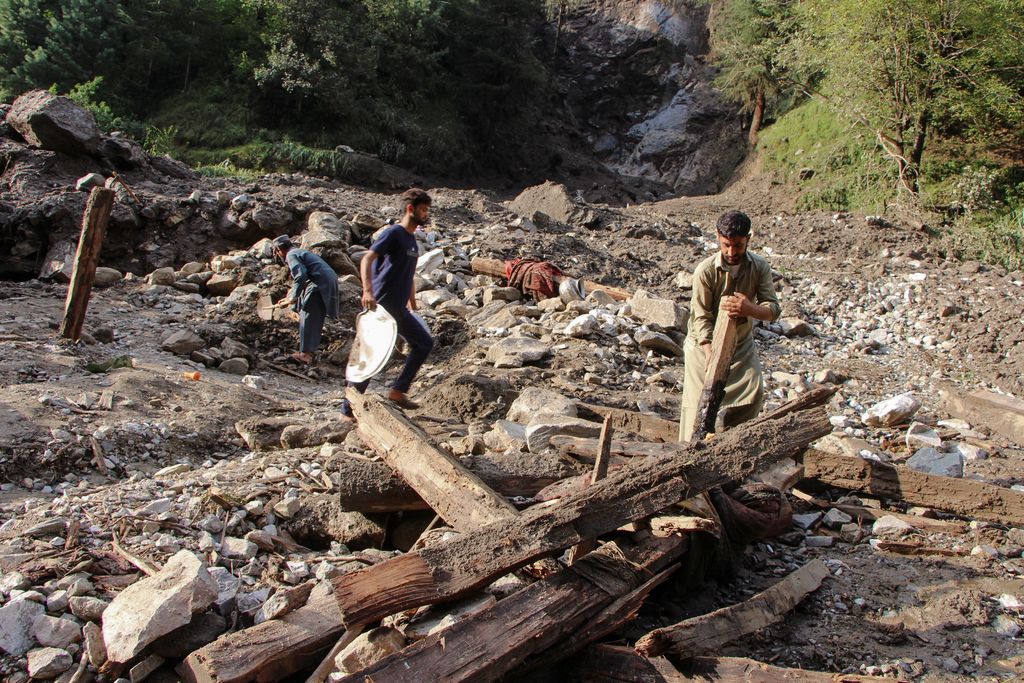 Orang-orang berkumpul di lokasi banjir bandang di Tehsil Salarzai di distrik Bajaur, Pakistan. Korban jiwa akibat hujan monsun deras yang memicu tanah longsor dan banjir bandang di wilayah utara Pakistan terus bertambah. Hingga Sabtu, 16 Agustus 2025, sedikitnya 194 orang dilaporkan meninggal. (REUTERS/Stringer)