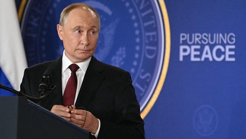 Russian President Vladimir Putin holds his earpiece during a joint press conference with US President Donald Trump (out of frame) after participating in a US-Russia summit on Ukraine at Joint Base Elmendorf-Richardson in Anchorage, Alaska, on August 15, 2025. (Photo by ANDREW CABALLERO-REYNOLDS / AFP)