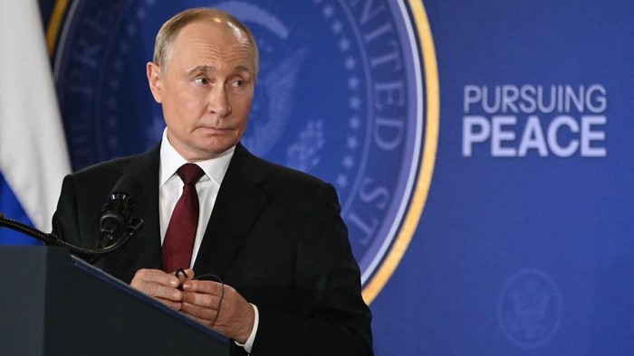 Russian President Vladimir Putin holds his earpiece during a joint press conference with US President Donald Trump (out of frame) after participating in a US-Russia summit on Ukraine at Joint Base Elmendorf-Richardson in Anchorage, Alaska, on August 15, 2025. (Photo by ANDREW CABALLERO-REYNOLDS / AFP)