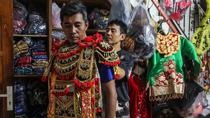 Pemilik bisnis melayani calon konsumen mencoba busana adat Bali sebelum disewa di Saraswati Collection, Semarang, Jawa Tengah, Sabtu (16/8/2025). Menurut pemilik usaha, permintaan penyewaan berbagai macam busana dan aksesoris adat tradisional untuk keperluan perayaan HUT ke-80 Republik Indonesia meningkat dari 20 set baju menjadi 500 set baju dengan harga Rp150 ribu hingga Rp1 juta per set tergantung ukuran dan jenis baju adatnya. ANTARA FOTO/Makna Zaezar/foc.