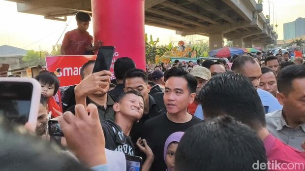 Wakil Presiden RI, Gibran Rakabuming Raka menonton langsung keseruan lomba panjat pinang di aliran Kalimalang, Jakarta Timur. (Kurniawan F/detikcom)