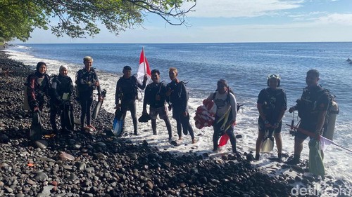 Guide dari OPST saat akan melakukan upacara dan pembentangan bendera merah putih di bawah laut Pantai Tulamben, Minggu (17/8/2025).