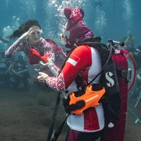 Mengenakan kostum putri duyung bernuansa merah-putih, Sherly melakukan freediving sambil membawa bendera. Foto: Instagram/@s_tjo