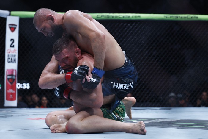 Aug 16, 2025; Chicago, Illinois, UNITED STATES; Dricus Du Plessis Murphy (red gloves) fights Khamzat Chimaev (blue gloves) during UFC 319 at United Center. Mandatory Credit: Kamil Krzaczynski-Imagn Images