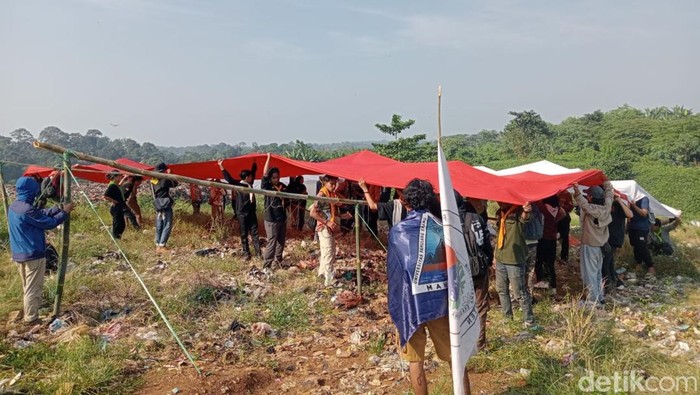 Mahasiswa melakukan pengibaran bendera merah putih di TPA Bangkonol. (Aris Rivaldo/detikcom).