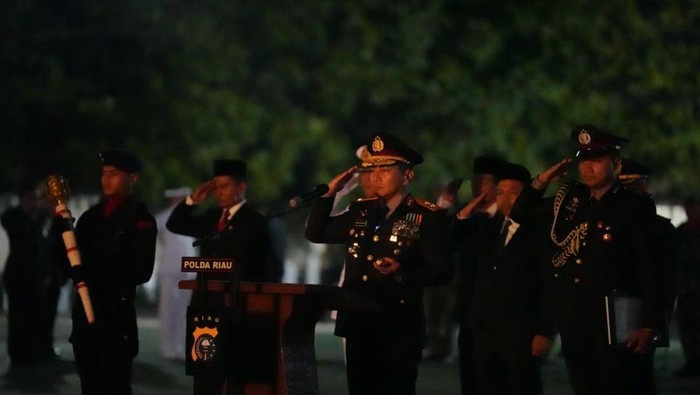 Momen khidmat Polda Riau gelar apel kehormatan dan renungan suci dalam memperingati HUT ke-80 RI di Taman Makam Pahlawan Kusuma Darma, Minggu (17/8/2025).