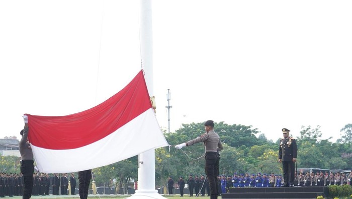 Momen pengibaran bendera Merah Putih pada HUT RI ke-80 di Polda Riau, Sabtu (17/8/2025).