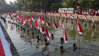 Warga membawa bendera Merah Putih saat prosesi upacara pengibaran bendera di Kanal Surosowan, Kampung Wisata Sukadiri, Kasemen, Kota Serang, Banten, Minggu (17/8/2025). Upacara yang digelar dengan mengibarkan sebanyak 80 bendera Merah Putih dan diikuti oleh ratusan warga tersebut untuk memperingati HUT ke-80 Kemerdekaan Republik Indonesia, sekaligus mempromosikan potensi wisata di Kampung Wisata Sukadiri. ANTARA FOTO/Angga Budhiyanto