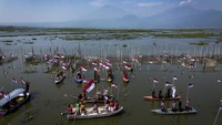 Foto udara upacara HUT ke-80 RI di Danau Rawa Pening, Tuntang, Kabupaten Semarang, Jawa Tengah, Minggu (17/8/2025). Lembaga Kesenian dan Kebudayaan (LKK) Kabupaten Semarang menggelar upacara tersebut selain untuk mengenang jasa para pahlawan kemerdekaan, juga untuk mengkampanyekan pentingnya pelestarian lingkungan sekaligus mempromosikan potensi wisata alam danau terbesar di Jawa Tengah kepada wisatawan lokal maupun mancanegara. ANTARA FOTO/Aprillio Akbar