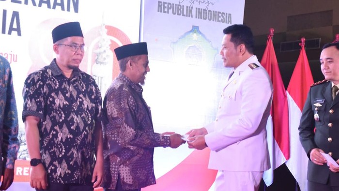 Bupati Sidoarjo Subandi menyerahkan bantuan ke eks napiter Umar Patek usai upacara HUT ke-80 RI