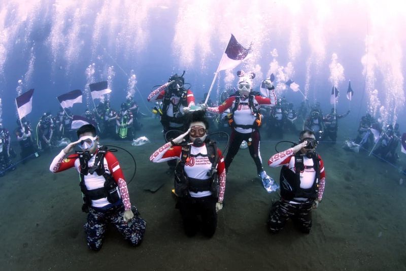 Pengibaran bendera merah putih di bawah laut di Maluku Utara.