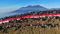 Sejumlah pendaki mengikuti upacara bendera di kawasan Puncak Pawitra Gunung Penanggungan, Kabupaten Mojokerto, Jawa Timur, Minggu (17/8/2025). Sekitar lima ribu pendaki dari berbagai daerah melakukan pendakian dan mengikuti upacara memperingati HUT ke-80 RI di gunung tersebut dengan membentangkan bendera Merah Putih sepanjang seribu meter. ANTARA FOTO/Muhammad Mada