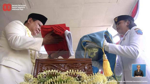 Presiden Prabowo Subianto memberikan bendera pusaka kepada pengibar bendera dalam upacara peringatan detik-detik proklamasi di Istana Merdeka, Jakarta, Minggu (17/8/2025). (Tangkapan Layar Youtube/Sekretariat Presiden)