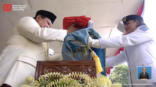 Presiden Prabowo Subianto memberikan bendera pusaka kepada pengibar bendera dalam upacara peringatan detik-detik proklamasi di Istana Merdeka, Jakarta, Minggu (17/8/2025). (Tangkapan Layar Youtube/Sekretariat Presiden)