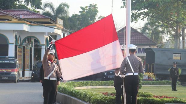 Prosesi pengibaran bendera Merah Putih di Polres Pelalawan berlangsung khidmat.