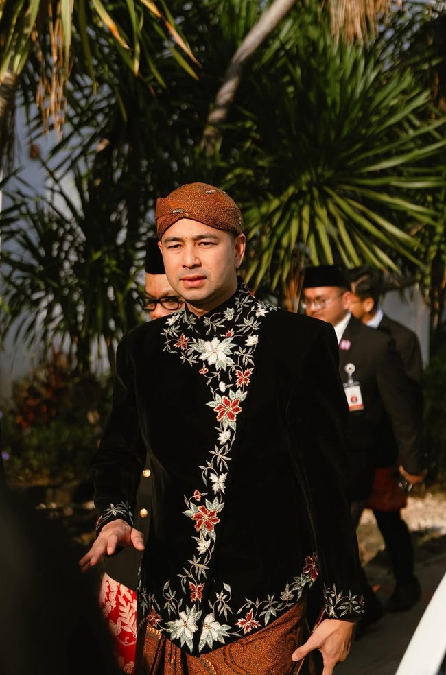 Raffi memilih beskap hitam berbahan beludru dengan detail bordiran bunga berwarna emas dan merah yang membuat tampilannya elegan. Sentuhan bordir ini memberi kesan mewah namun tetap klasik. Foto: Instagram/@raffinagita1717
