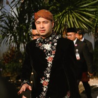 Raffi memilih beskap hitam berbahan beludru dengan detail bordiran bunga berwarna emas dan merah yang membuat tampilannya elegan. Sentuhan bordir ini memberi kesan mewah namun tetap klasik. Foto: Instagram/@raffinagita1717