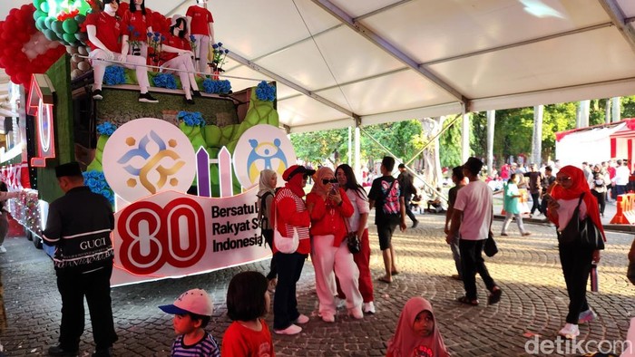 Sejumlah mobil karnaval berjejer di kawasan Monas, Jakarta Pusat, dalam rangka peringatan HUT ke-80 RI. Deretan mobil itu diserbu warga untuk berfoto. (Adrial/detikcom).