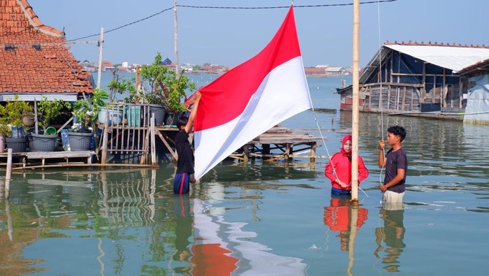 Suasana upacara warga Dukuh Timbulsloko, Kecamatan Sayung, Kabupaten Demak di tengah rob, Minggu (17/8/2025).