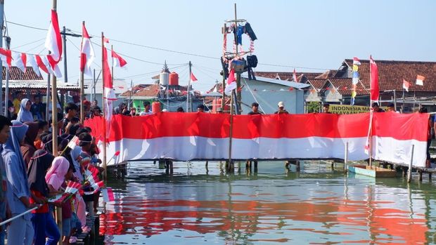Suasana upacara warga Dukuh Timbulsloko, Kecamatan Sayung, Kabupaten Demak di tengah rob, Minggu (17/8/2025).