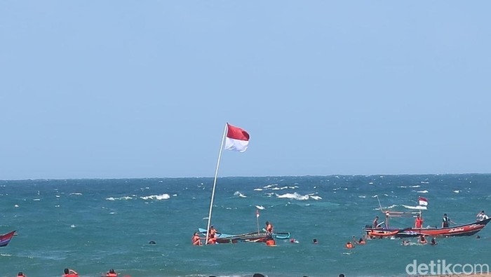 Prosesi upacara pengibaran Merah Putih di Pantai Baron, Gunungkidul, Minggu (17/8/2025).