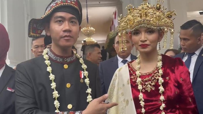 Wapres Gibran tampak mengenakan baju adat Gayo berwarna hitam, sedangkan istrinya Selvi Ananda mengenakan baju adat klasik Palembang