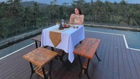 Liburan ke Magelang, Wulan Guritno menikmati pemandangan senja yang syahdu. Momennya semakin lengkap dengan makanan yang tersaji di atas meja. Foto: Instagram wulanguritno