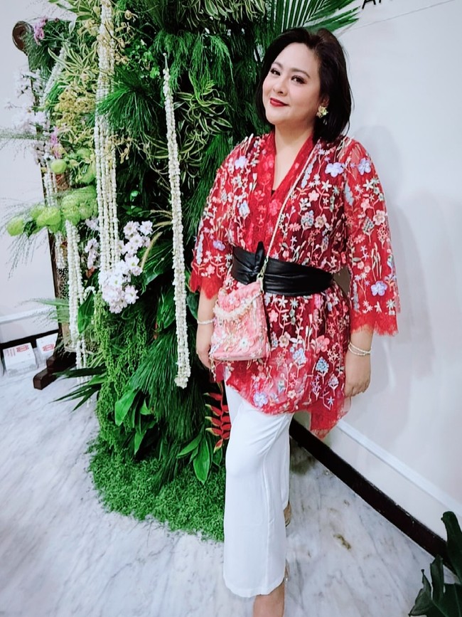 Datang untuk mendampingi suaminya, Iko Uwais, yang ambil bagian sebagai salah satu penampil, Audy Item memilih gaya yang lebih praktis. Kebaya modifikasi bergaya kimono dalam motif floral yang meriah dipasangkan dengan celana panjang putih. (Foto: Instagram)