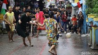 Beberapa perlombaan unik, seperti sepakbola mengenakan daster dan menyangkutkan pengait ke lingkaran kawat, berhasil menarik perhatian warga sekitar maupun pengendara yang melintas, di Jalan Petamburan II, Tanah Abang, Jakarta Pusat, Senin (18/8/2025).