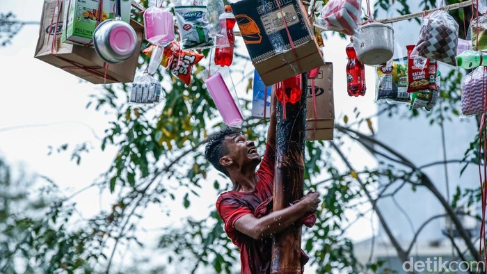 Suasana meriah tampak di aliran Sungai Bekasi, RW 02, Margajaya, Senin (18/8/2025), saat warga mengikuti lomba panjat pinang yang digelar dalam rangka memeriahkan HUT Kemerdekaan RI. Para peserta harus berjuang menaklukkan batang pinang yang licin di atas aliran air demi memperebutkan hadiah perabotan rumah tangga dan uang tunai senilai Rp 1 juta.