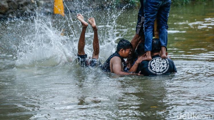 Jatuh Bangun, Peserta Akhirnya Taklukkan Pinang di Tengah Sungai Bekasi