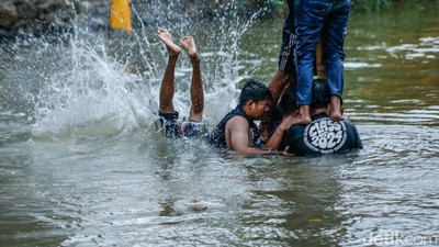 Jatuh Bangun, Peserta Akhirnya Taklukkan Pinang di Tengah Sungai Bekasi