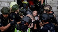 Tim penyelamat dan polisi membawa seorang pria yang diselamatkan dari reruntuhan gedung apartemen yang terkena serangan pesawat tak berawak Rusia, di tengah serangan Rusia terhadap Ukraina, di Kharkiv, Ukraina, Senin (18/8/2025). REUTERS/Sofiia Gatilova