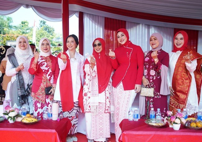 Margin memilih atasan kebaya janggan polos berwarna merah berpadu kain batik putih bermotif warna pink. Atasan yang dikenakan dihiasi detail rantai kecil yang menjuntai di bagian dada sehingga menambah kesan mewah. Foto: Instagram/@marginw