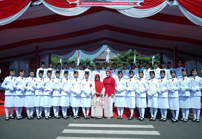 Penampilan Margin dilengkapi dengan hijab merah yang rapi menutup kepalanya memberi kesan anggun sekaligus sopan. Ia juga menenteng tas putih kecil yang senada dengan nuansa merah-putih pada outfitnya. Foto: Instagram/@marginw