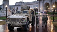 Tentara Garda Nasional berjaga di sejumlah titik strategis, sementara warga beraktivitas di sekitarnya dengan berbagai respons. REUTERS/Alexander Drago