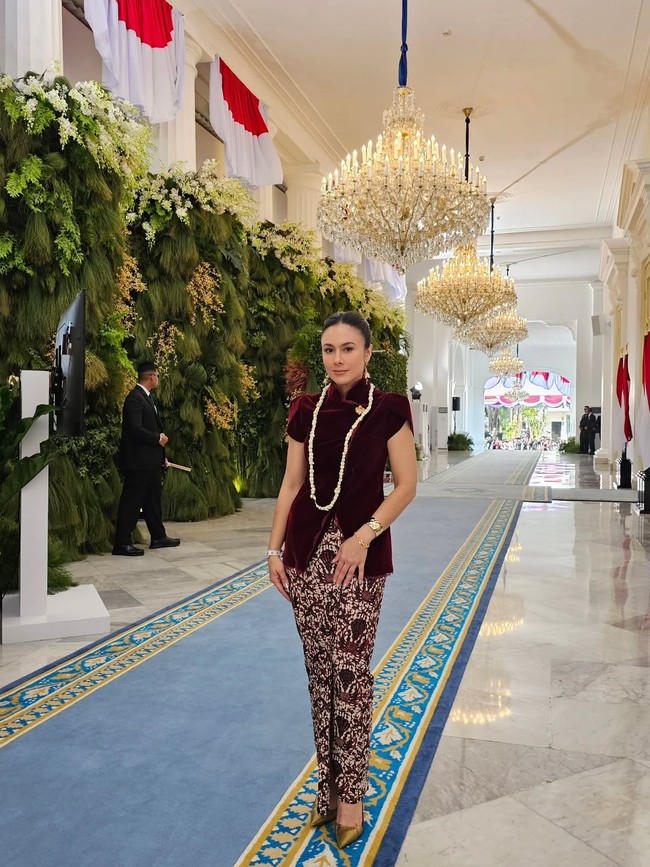 Wulan Guritno memberikan gaya terbaiknya dengan kabaya janggan berbahan beludu (velvet) merah dari koleksi Sissae Indonesia. Atasan tersebut dipermanis dengan bros bunga keemasan. Untuk bawahan, ia memilih kain batik bernuansa sogan yang klasik. (Foto: Instagram @wulanguritno)