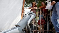 Anjing robot Waldog berinteraksi dengan anak-anak di Monterrey, Meksiko. Waldog hadir untuk mengampanyekan kesejahteraan hewan jalanan. Foto: REUTERS/Daniel Becerril