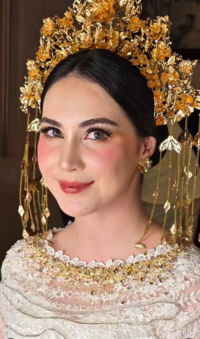 Arumi Bachsin memakai setelan putih dengan bawahan songket dilengkapi hiasan kepala dan perhiasan emas. Foto: Instagram Arumi Bachsin