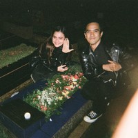 Rachquel Nesia dan Kevin Royano berpose di samping makam setelah prosesi lamaran. Senyum bahagia terpancar di tengah suasana yang penuh makna dan haru. Foto: Dok. Instagram @rachquelnes.