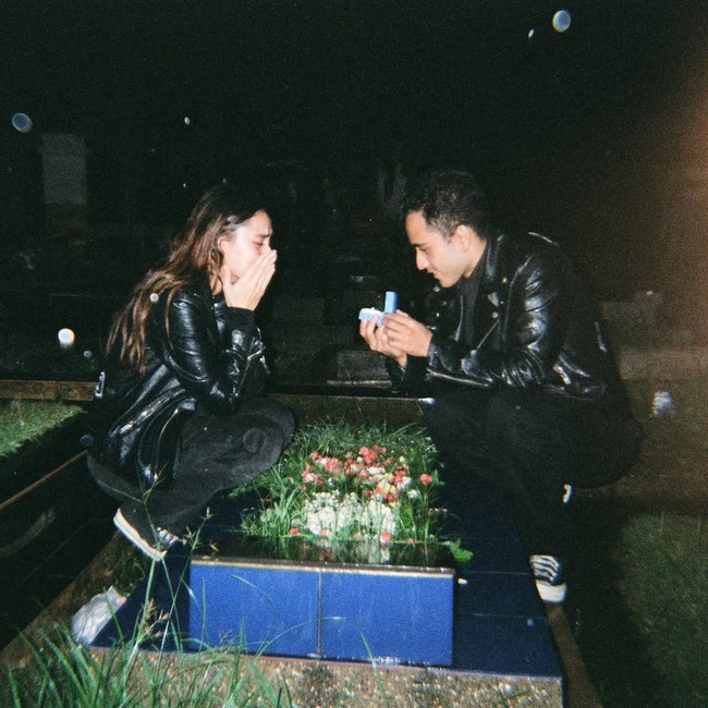 Rachquel Nesia terharu ketika Kevin Royano berlutut dan membuka kotak cincin lamaran di depan makam sang ayah, dalam suasana malam yang hening dan penuh haru pada 14 Agustus 2025. Foto: Dok. Instagram @rachquelnes.