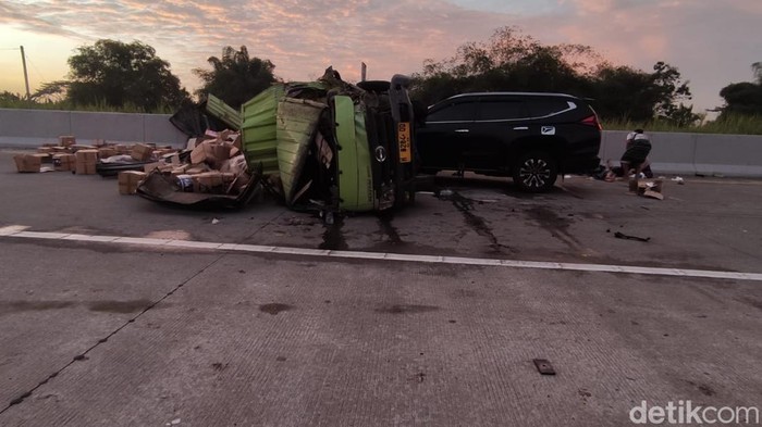 Penampakan truk boks yang melintang di jalan dengan kondisi remuk dan muatan berhamburan usai terlibat kecelakaan di Tol Solo Ngawi Km 529+200, Sragen, Selasa (19/8/2025).